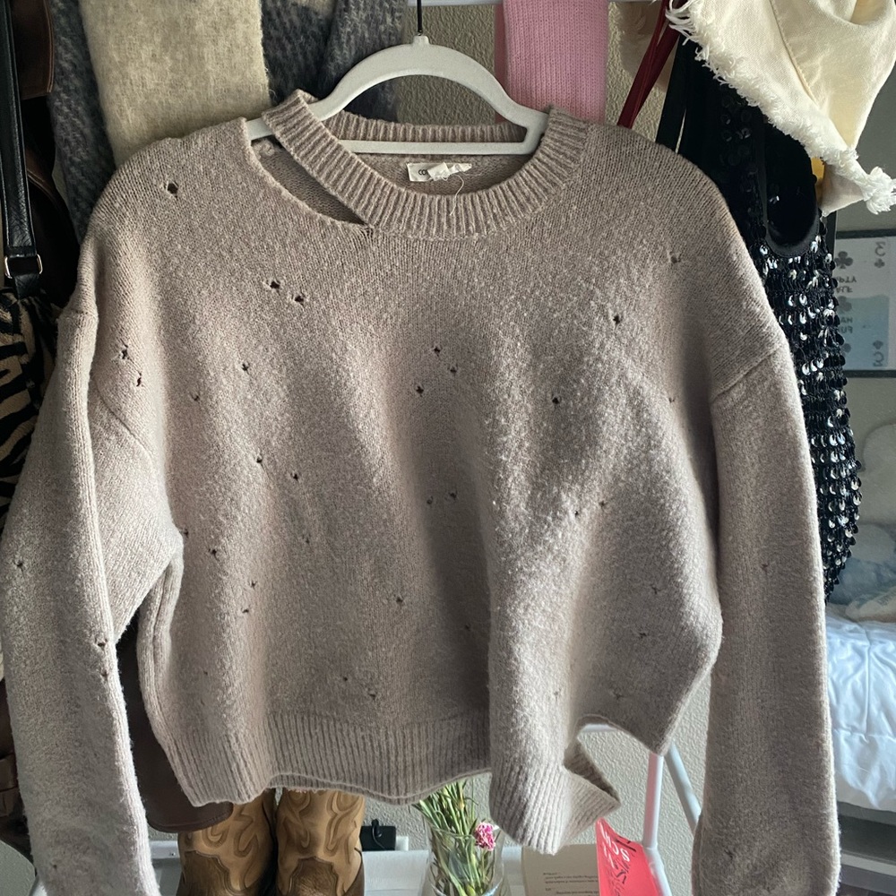 Beige sweater with hole and cut out detailing.